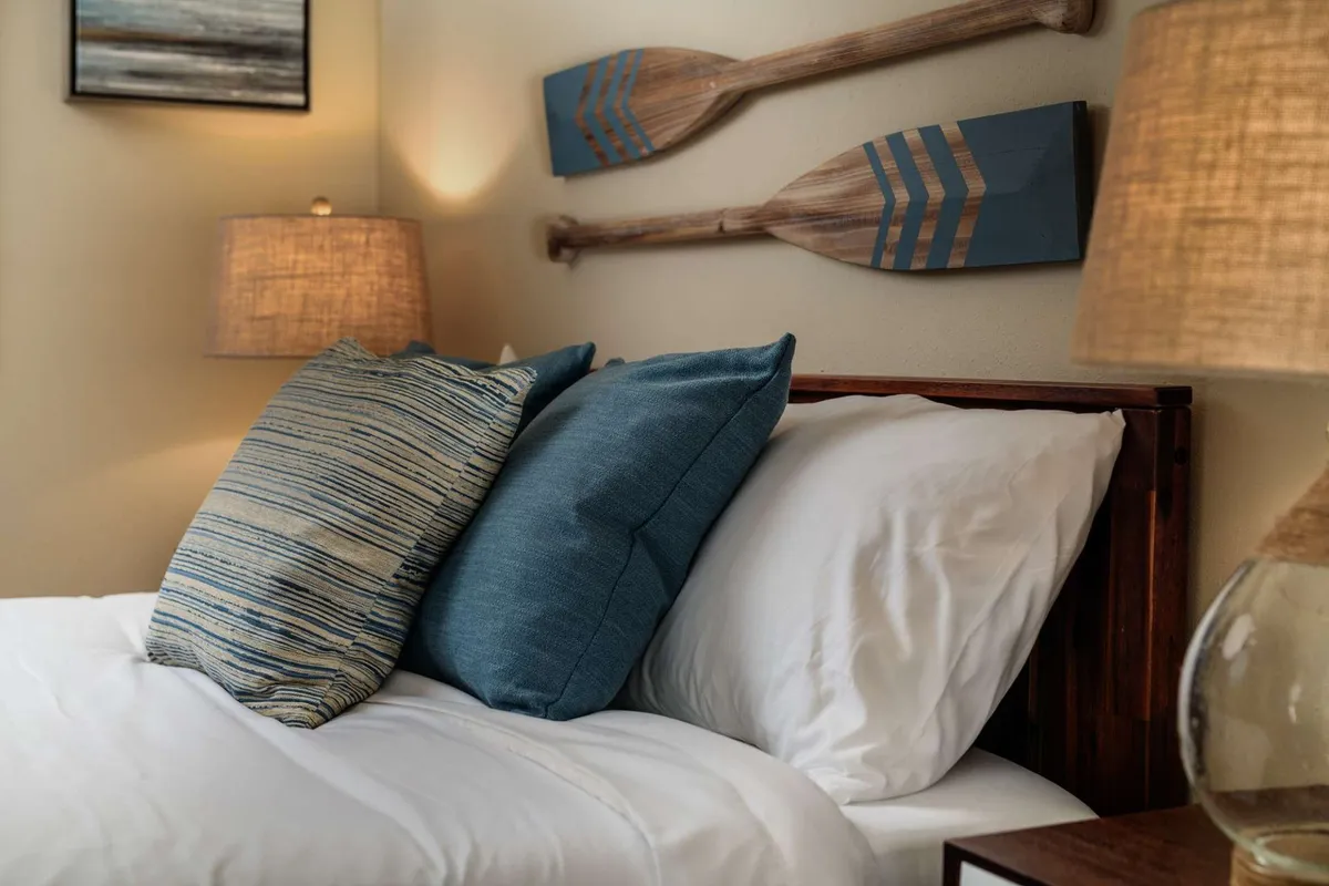 A serene seating area with decorative paddles on the wall, plush pillows, and soft lighting from lamps, creating a comfortable, intimate setting. The layout encourages conversation and relaxation among friends.